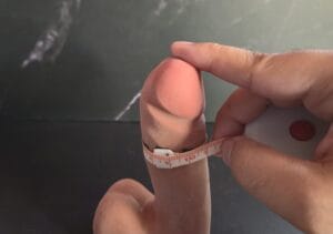 Measuring circumference of erect penis with tape measure