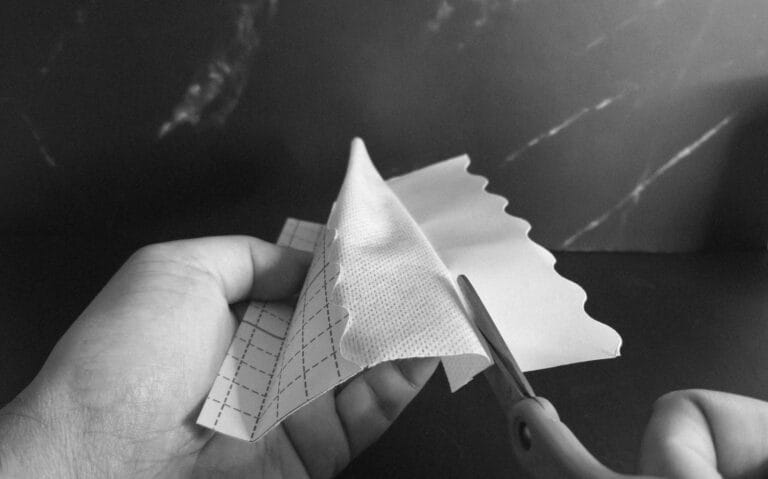 Black and white photo of manually cutting t-tape tabs