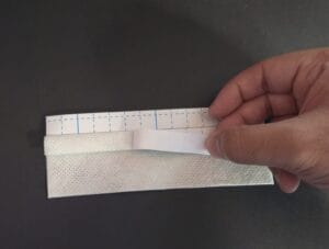 Removing the peels of the top tabs of a t-tape